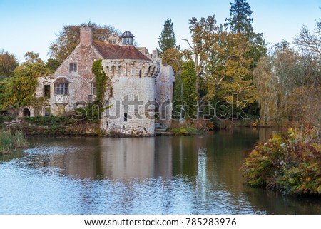 a reflection of Old Scotney castle in moat waters on a sunny day 