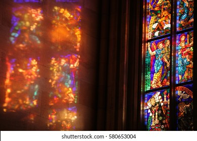 Reflection Of Old Stained Glass On The Wall In Catholic Church