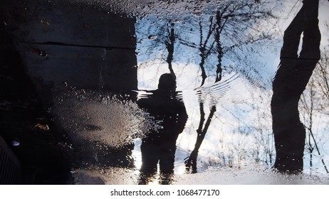 reflection on man in puddle. rainy weather. 