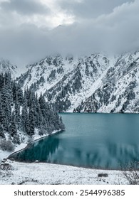 Reflection on mountains and trees covered with snow in Big Almaty lake in Kazakhstan