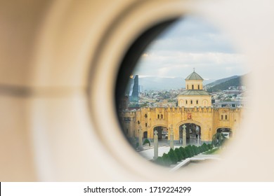 Reflection on viewer eye of Holy trinity cathedral gates towew with city panorama. Concept of culture sights and travel in Georgia during pandemic.2020