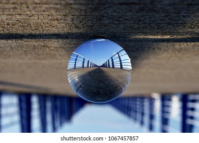 Reflection of a pier in a glass ball