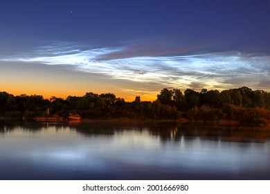 Reflection in the river Noctilucent clouds. Summer nights