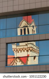 The reflection of the sacral object on the glass of a modern building