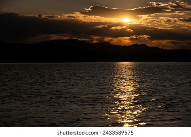 Reflection and setting of the sun and dense clouds and the sun behind the cloud