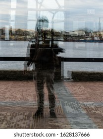 Reflection shot of a man standing in front of a window.