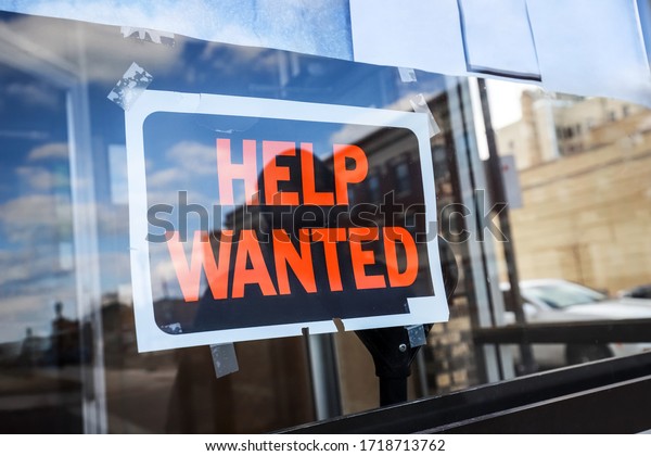 Reflection of a silhouette of a man looking at a\
help wanted sign in a business window, economy concept, shallow\
focus on middle of\
sign