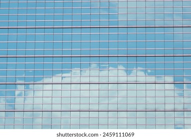 Reflection of the sky with clouds from the glass of a large building.