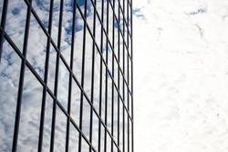 Structural glass wall reflecting blue sky. Abstract modern architecture ...