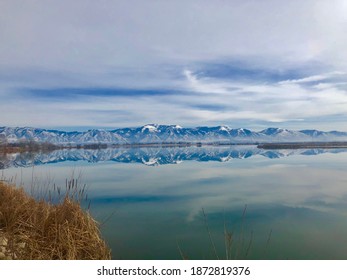 Reflection of a snow covered mountain range on a lake in Utah.
