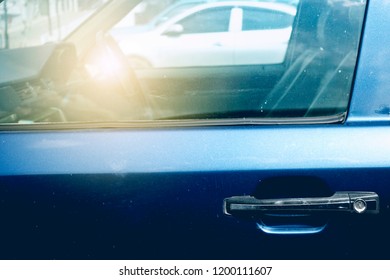 Reflection of the sun and sunlight on the window of the car in the outdoor parking lot.