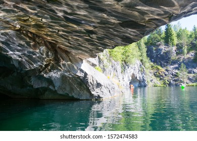 Reflection of sunlight from the surface of the lake on the ceiling of the cave in marble canyon in Ruskeala