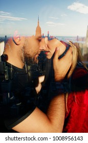 Reflection of tender hugging couple in a window with great view on the New York city