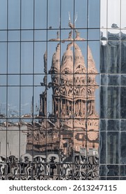 Reflection of the Texas State Capitol dome in the multiple glass windows of modern skyscraper in Austin