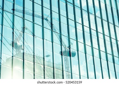 Reflection of tower cranes building construction on building mirror. Abstract background. - Powered by Shutterstock
