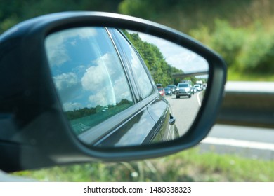 Reflection of traffic flow in car side mirror.