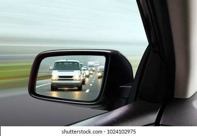 reflection of traffic flow in left side rear view mirror at twilight time