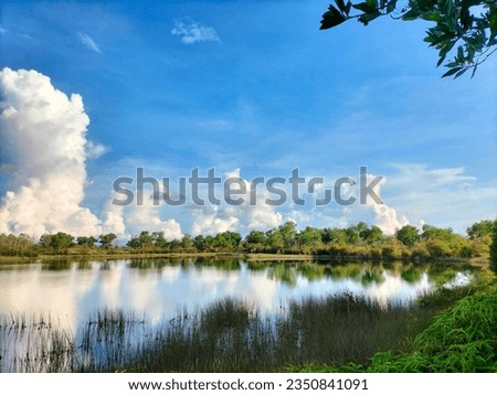 Reflection of Tranquil Nature: Greenery, Sky, and Lake