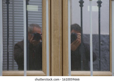 Reflection of two photographers in a window