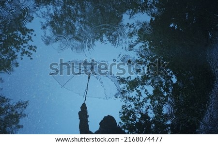 reflection umbrella in puddle, wet asphalt abstract natural background. rainy weather season. flat lay. copy space	