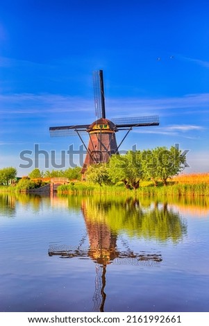 Reflection View of Traditional Romantic Dutch Windmills in Kinderdijk Village in the Netherlands Before Sunset. Vertical Image Composition