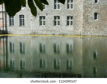 Reflection of wall with windows in water Belgium Gardens of Annevoie