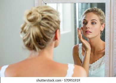 Reflection Of Woman Checking Her Skin In Bathroom Mirror