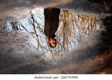 Reflection Of Woman In The Puddle