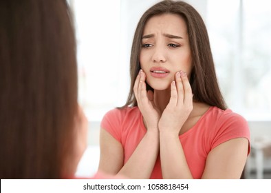 Reflection Of Woman With Sensitive Teeth In Mirror Indoors