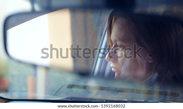 Reflection of a woman\'s\
face in the rearview mirror, a woman prepares a rear-view mirror\
before driving