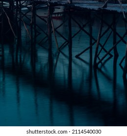 Reflection of a wooden bridge over blue sea water - Powered by Shutterstock