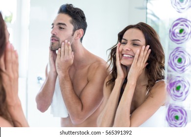 Reflection of young couple touching face in bathroom