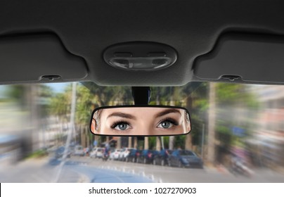 Reflection Of Young Woman In Car Rear View Mirror 