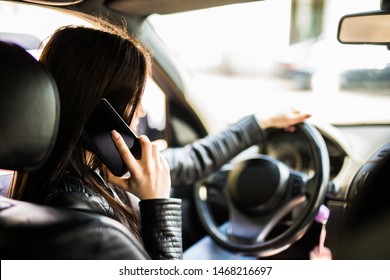 Reflection Of Young Woman Talking On A Mobile Phone In The Car Rear View Mirror. No Cell Phone, While Driving. Safe Driving Concept.