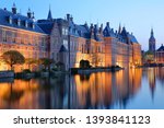 Reflections of the Binnenhof (13 century gothic castle) on the Hofvijver lake at dusk during the blue hour, with the clock tower of Grote of Sint Jacobskerk on the right, The Hague, Netherlands
