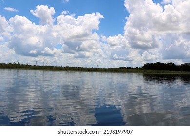 Reflections Of The Blue Sky And White Clouds In The Clear Lake Water