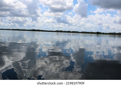 Reflections Of The Blue Sky And White Clouds In The Clear Lake Water