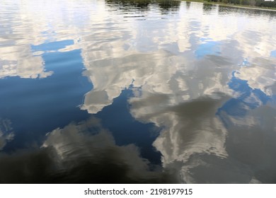 Reflections Of The Blue Sky And White Clouds In The Clear Lake Water