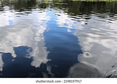 Reflections Of The Blue Sky And White Clouds In The Clear Lake Water