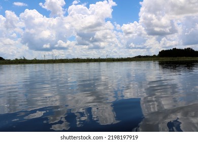 Reflections Of The Blue Sky And White Clouds In The Clear Lake Water