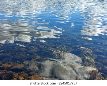 Reflections of clouds on water with smooth waves.