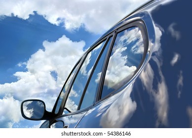 Reflections Of The Clouds In The Polish Of The Brand New Car. Focus Is On The Front Car Window. Reflections And The Sky Create Deep Palette Of Blue Color In The Whole Picture.