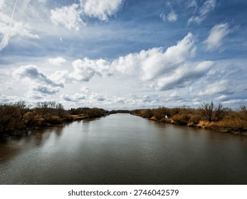 Reflections on the Scheldt Beneath Dramatic Clouds