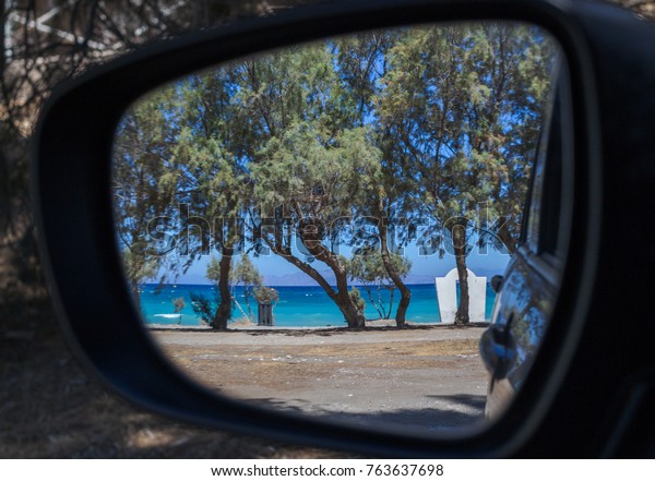 Reflections in a side view mirror of a car\
driving on the beach. Rear view car mirror. Concept of 4wd off-road\
driving in the\
nature.