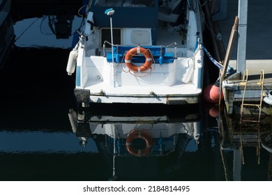 Reflections Of White Boat With Red Lifesaver Docked At Edmonds Marina, Washington