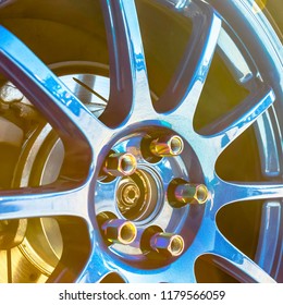 Reflective Blue Rims Of A Car With Gold Bolts