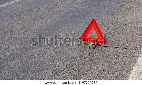 Reflective Emergency Triangle positioned\
remotely on asphalt to signal traffic\
accident