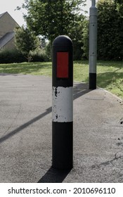 Reflective post at the end of a pavement warning pedestrians of the main road in a small village in England