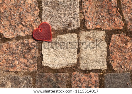 Reflector in the form of a heart on a paving stone in a park. Happy, Love, Valentine's Day, relationship, sign, symbol, concept
