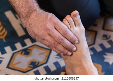 A Reflexologist Is Seen Up Close Using Hands To Apply Pressure To Zones In The Foot Of A Woman. Alternative Medicine Practice To Heal The Body.